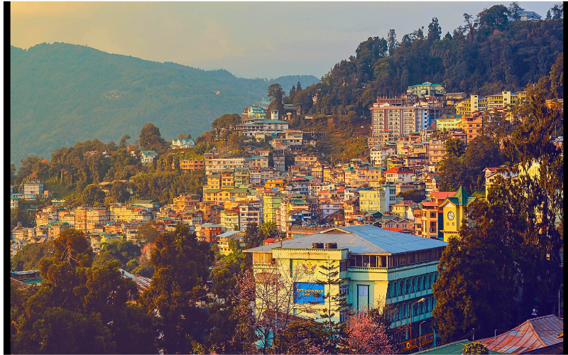 Closer view of Medellín’s hillside neighborhoods and city architecture glowing under golden sunlight, reflecting its pleasant spring-like climate.