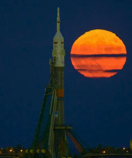 A glowing orange supermoon rises behind a Soyuz rocket on the launch pad, captured during the November 14, 2016 “Extra Supermoon,” the closest since 1948.